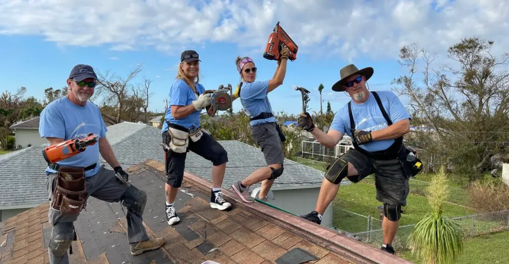 A group of Hope Force Reservists pose for a picture while working on a roof.