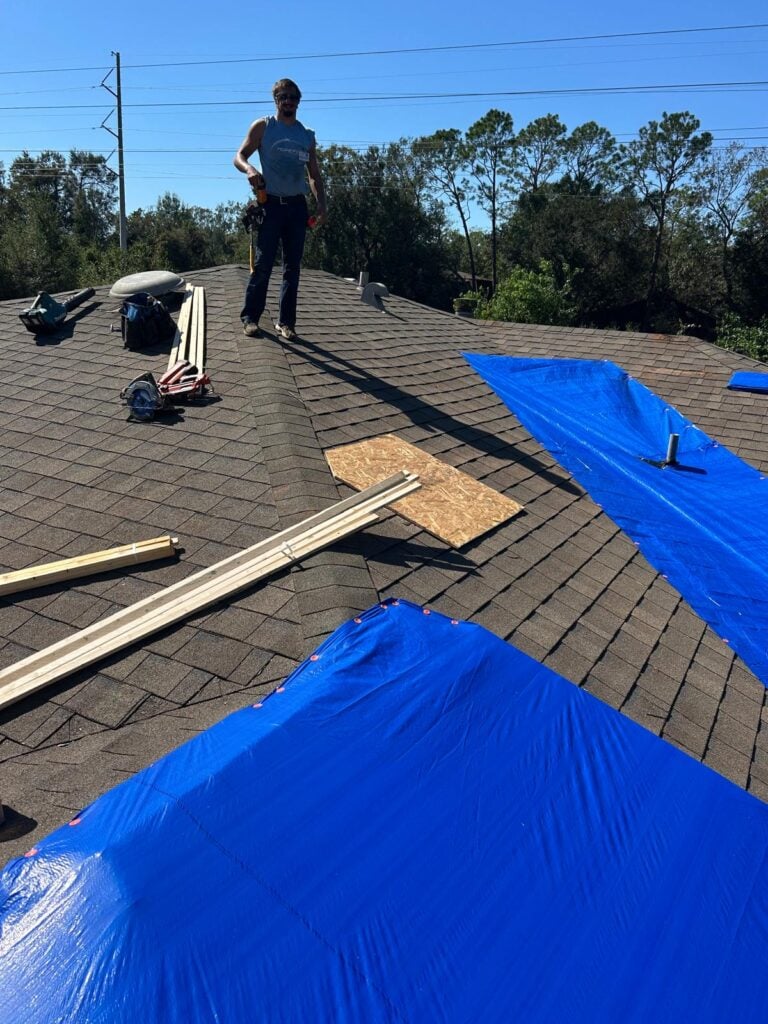 A Hope Force Reservist tarps a roof damaged by Hurricane Isaias.